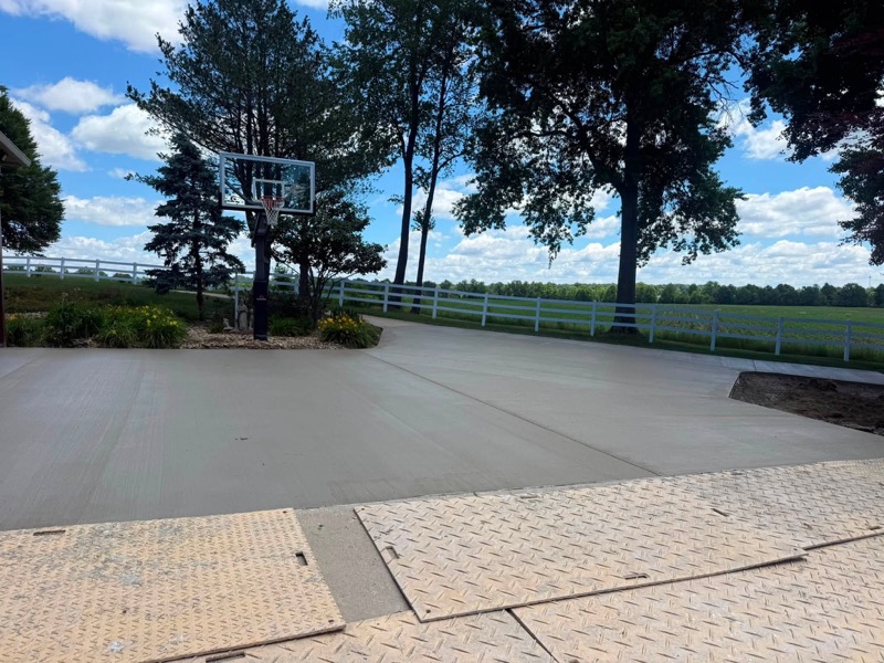 Large concrete basketball court pad on rural property