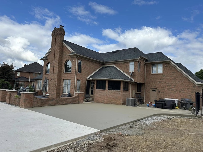 Large concrete pad behind upscale brick home